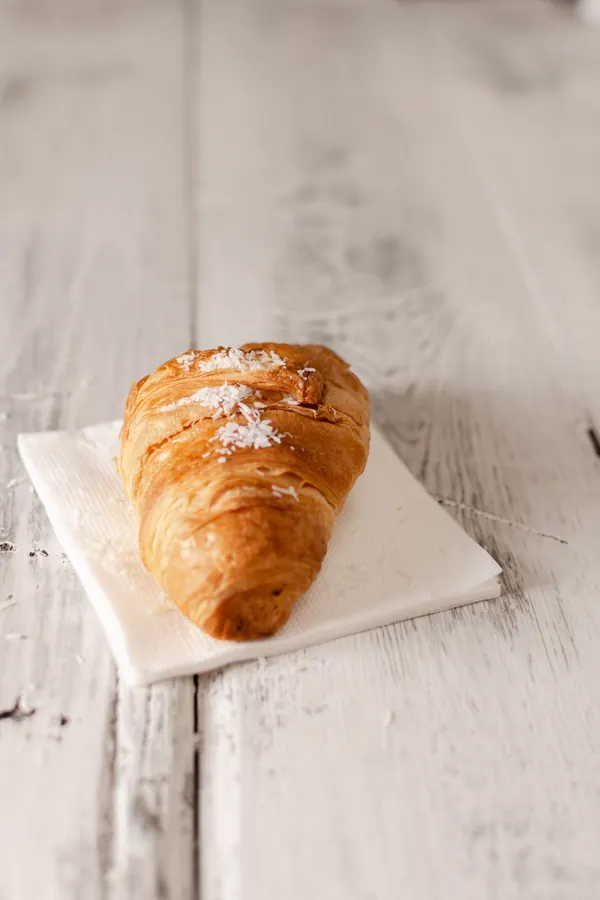 Croissant sobre una servilleta en una mesa de madera clara